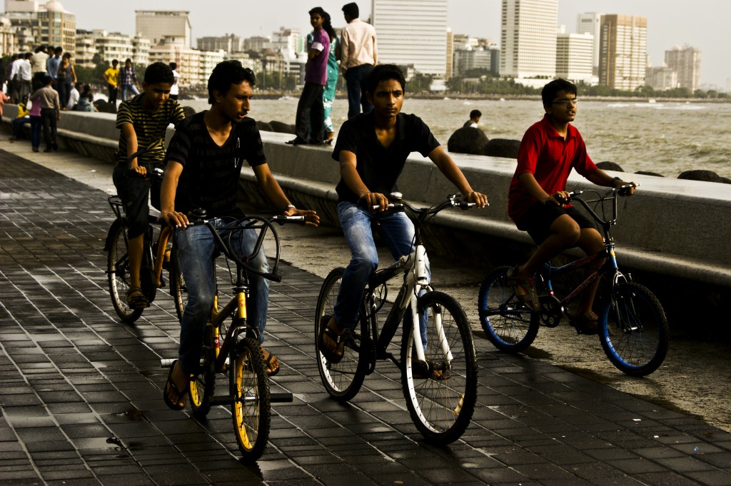 Kids out on their bikes, enjoying the weather, by the Marine Drive which over looks the Arabian Sea